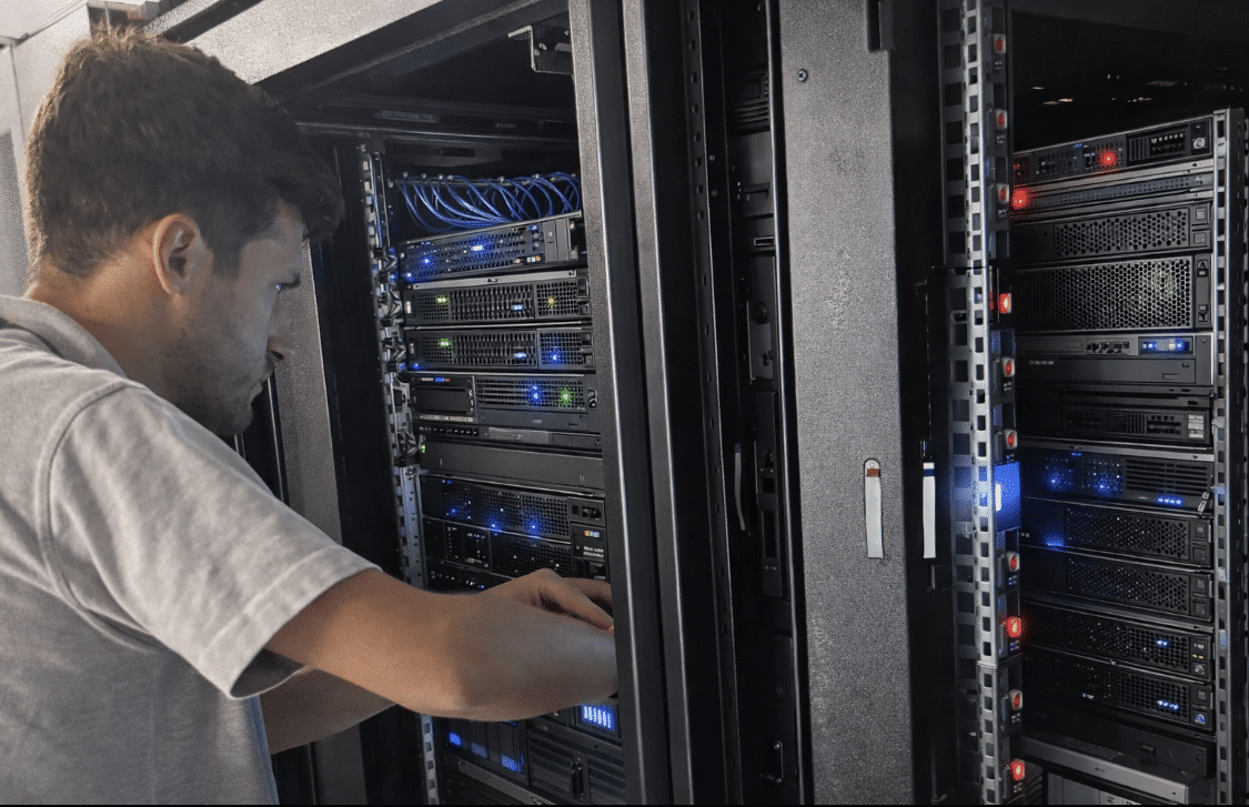 Man working on a server rack in a data center.
