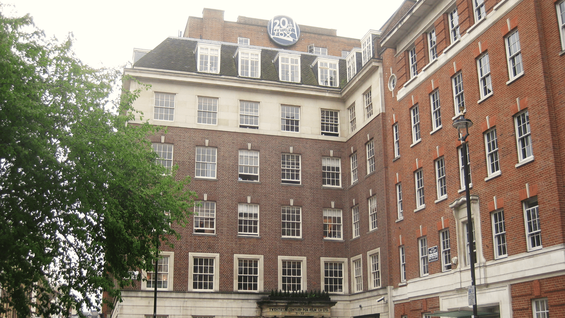 Case Study - 20th Century Fox Red brick building with many windows and a "20th Century Fox" sign on the roof.